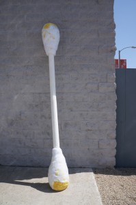 a giant q-tip leaning against a wall