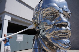 A giant q-tip pressed against the ear of the Los Angeles chrome Stalin sculpture by the artist Maxwell Coppola