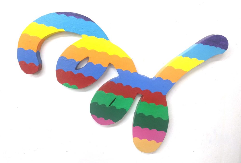 a shaped canvas with three curls and rainbow wavy stripes